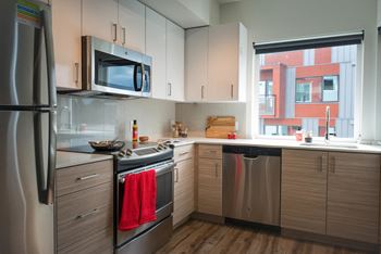 A kitchen with stainless steel appliances and a window